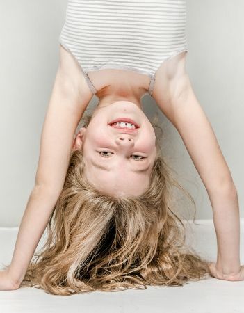 Image: Young girl doing handstand and laughing