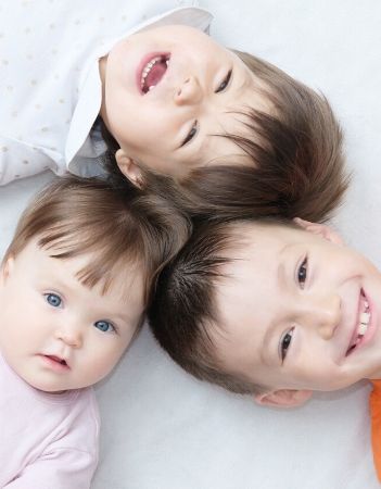 image: siblings laying on floor heads together