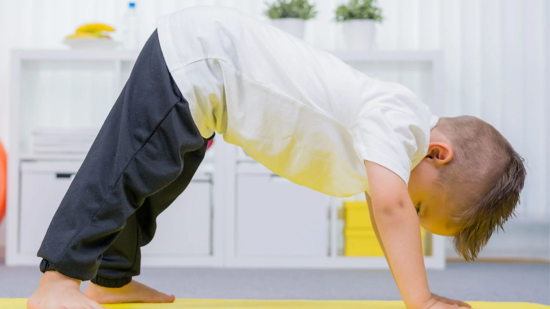 preschool boy on a yoga mat stretching